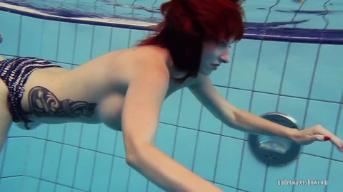 Sexy Russian redhead Katrin Privsem flaunts her big tits and tight pussy while swimming